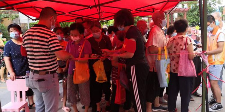 彭愛玲在維持做全員核酸檢測(cè)人員的秩序,協(xié)助居民掃碼填資料.jpg