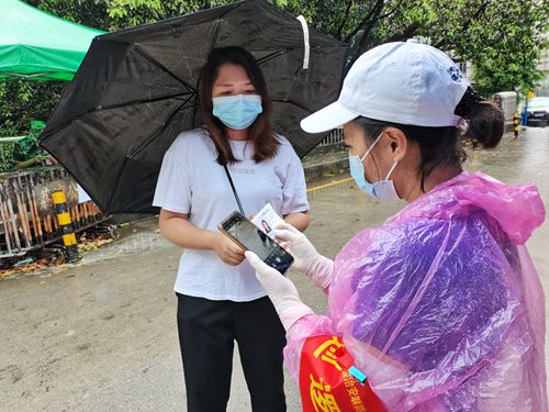 卜智群在封控小區(qū)門口檢查出入人員的出入證.jpg
