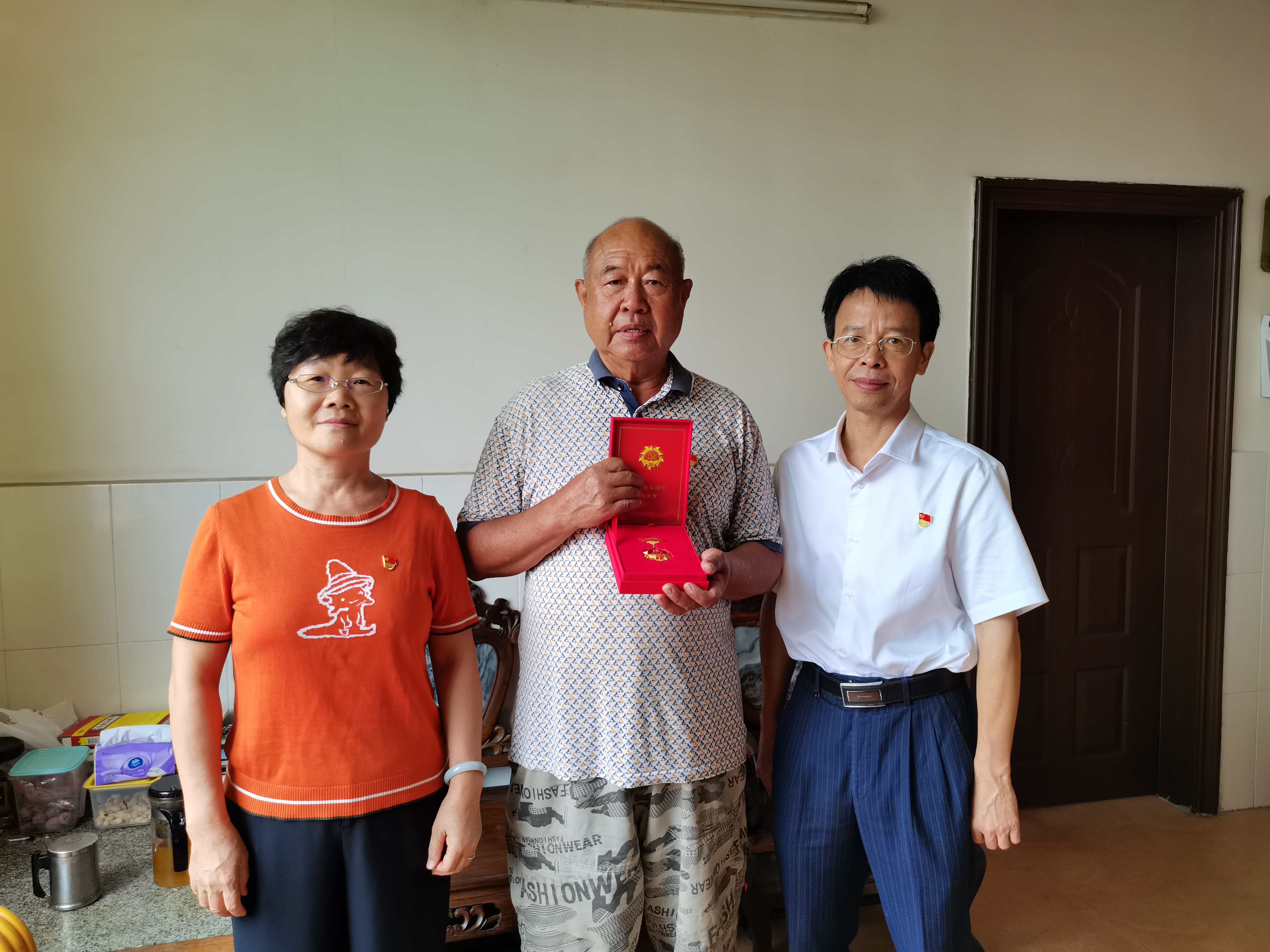 向老黨員黃金華（中）頒發(fā)紀念章.jpg